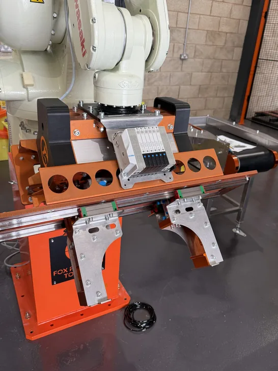 Fox Precision Tooling orange EOAT tooling assembly with pneumatic valves and electronics