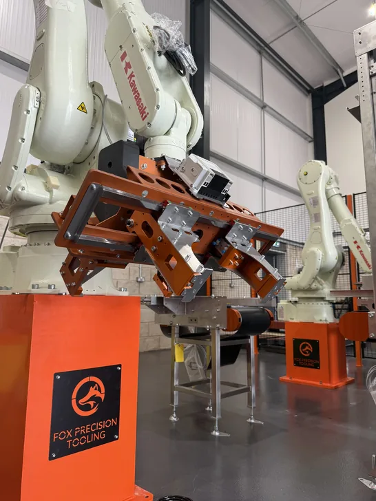Fox Precision Tooling six-axis robot arm close-up with orange EOAT gripper