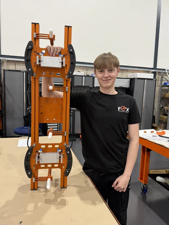 Fox Precision Tooling team member standing with a finished EOAT build