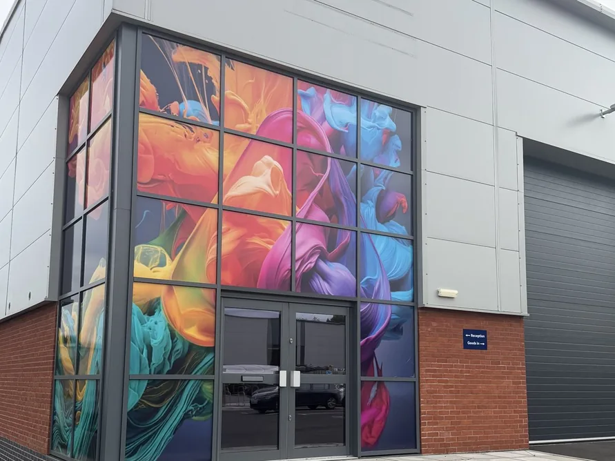 Entrance to Fox Precision Tooling's new unit, with a colourful mural wrap on the glazing above reception and goods-in signage