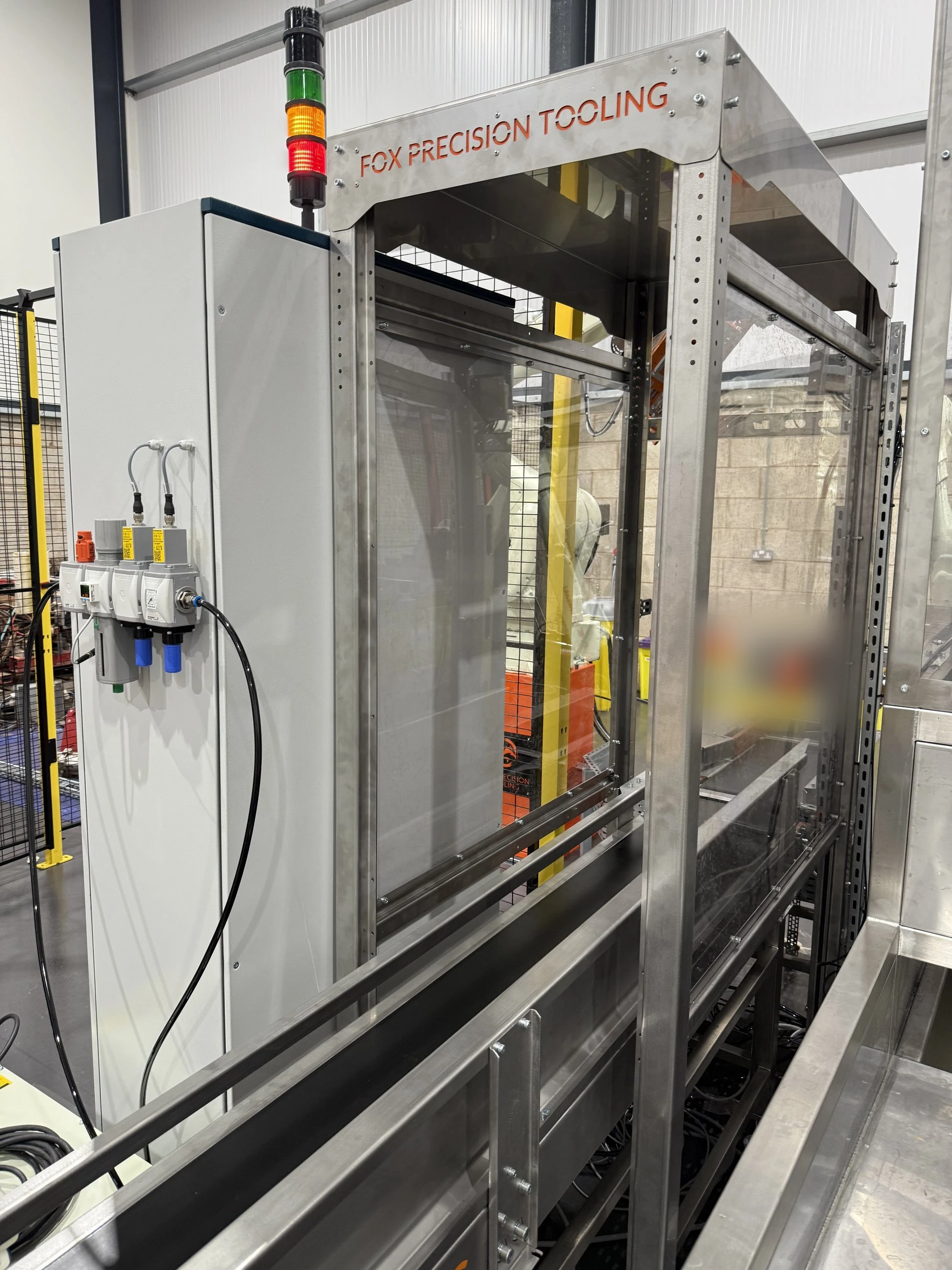 Fox Precision Tooling branded control cabinet and status light tower on an installed robot cell