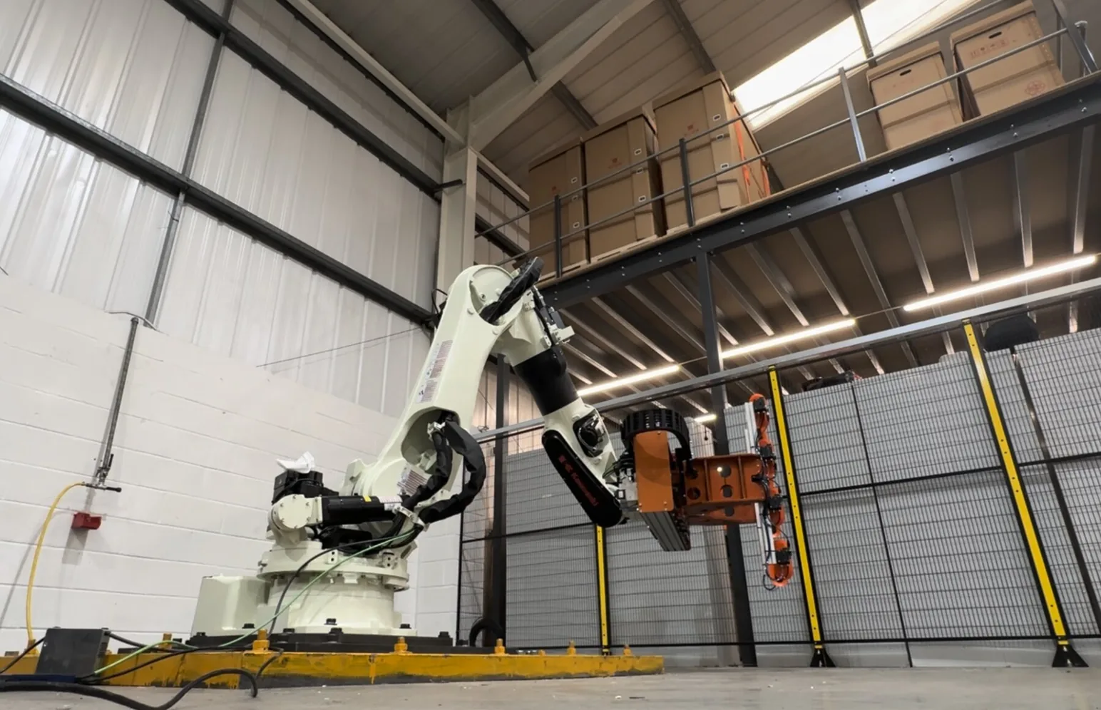 Fox Precision Tooling 6-axis robot cell with a custom EOAT retrieving cartons from a mezzanine store